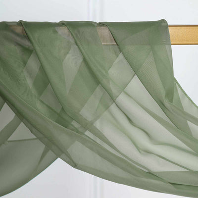 Sheer green fabric draped elegantly on a wooden rod.