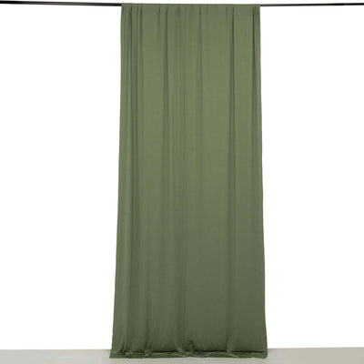 Olive green curtain draped on a rod against a plain backdrop
