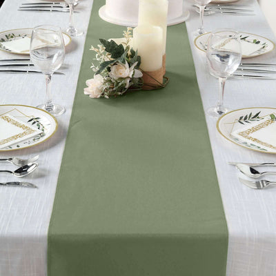 Olive green table runner on a beautifully set dining table with candles and floral decor.