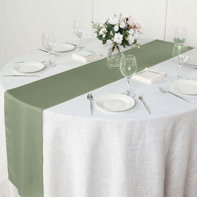 Olive green table runner on a round dining table set with plates and glasses.