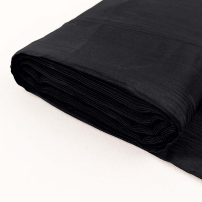 Black fabric roll, smooth texture, ideal for sewing and crafting projects.