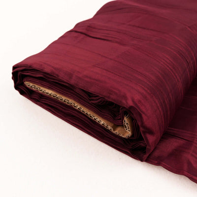 Burgundy fabric roll with textured finish, neatly folded for display.