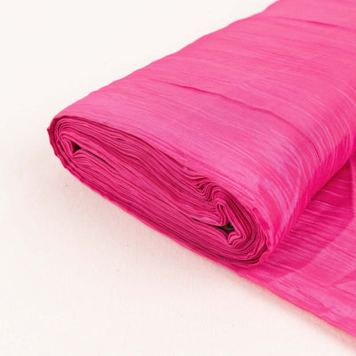 Rolled pink fabric on a plain background