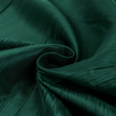 Emerald green fabric with smooth, flowing texture and subtle sheen.