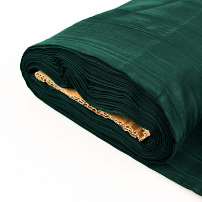 Rolled dark green fabric on a white background