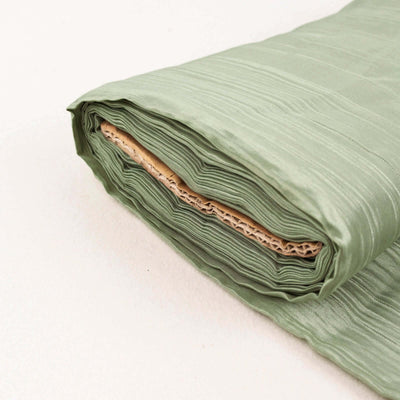 Rolled green fabric with textured surface on a plain backdrop.