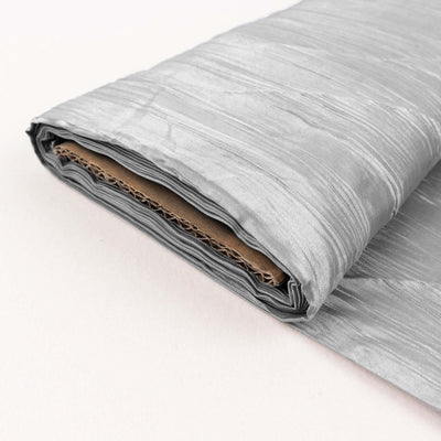Silver textured fabric roll on a light background.