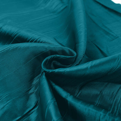 Teal silk fabric with smooth texture and gentle folds.