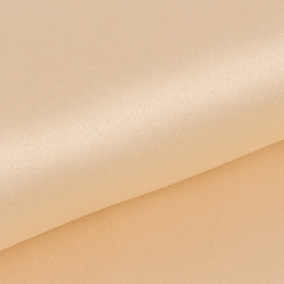 Soft peach satin fabric rolls for elegant designs and sewing projects.