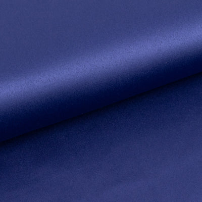 Navy blue satin fabric roll on a smooth surface.