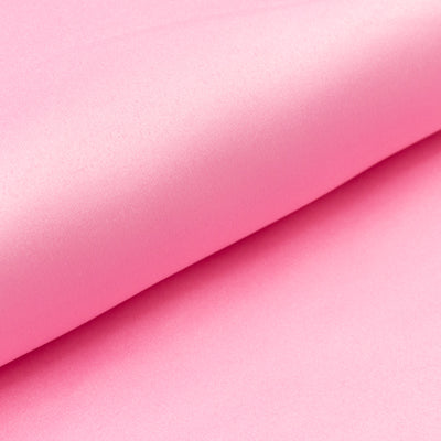Smooth pink satin fabric folded elegantly, showcasing its sheen and texture.
