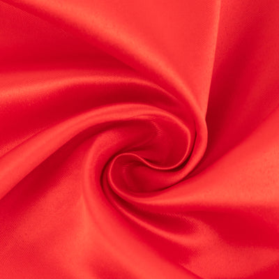 Red satin fabric texture in a swirling pattern.