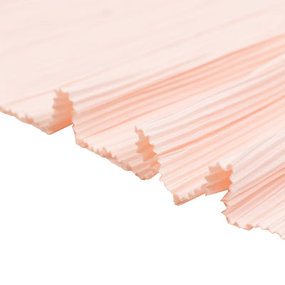 Soft pink pleated fabric texture close-up on white background