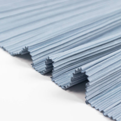 Blue pleated fabric swatches with textured edges on white background
