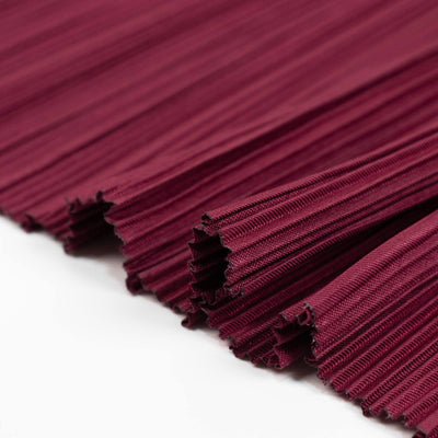 Burgundy pleated fabric close-up texture with folded edges