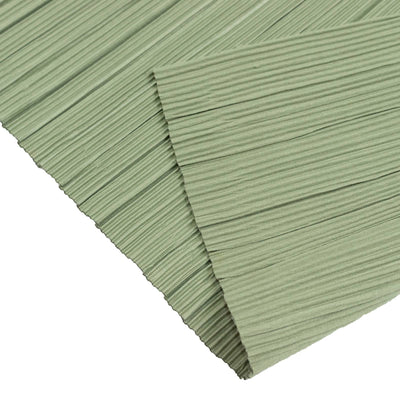 Green pleated fabric close-up texture with layered folds and ribbed pattern