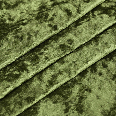 Green velvet fabric texture with diagonal folds close-up