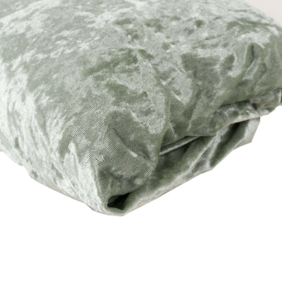 Soft green velvet fabric folded neatly on a white background.