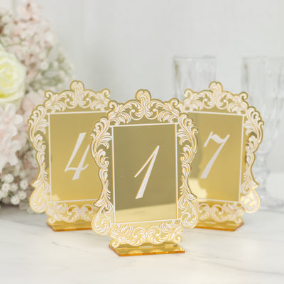 Elegant gold table numbers with ornate frames for weddings and events.