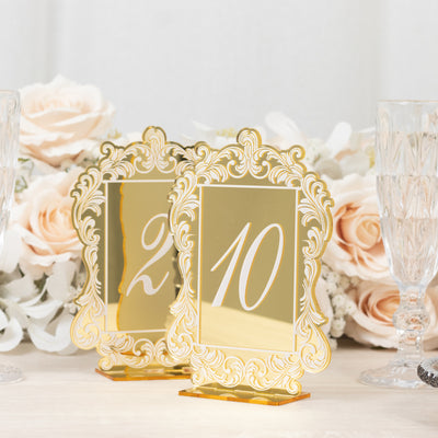 Elegant gold table numbers 2 and 10 with ornate frames on a neutral background.