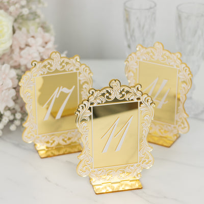 Elegant gold table number holders for events, featuring intricate designs.