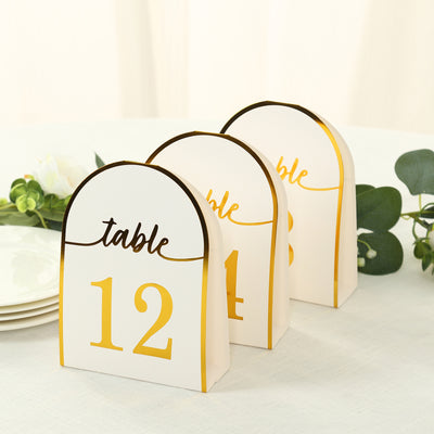 Elegant table number cards in gold and white, perfect for weddings and events.