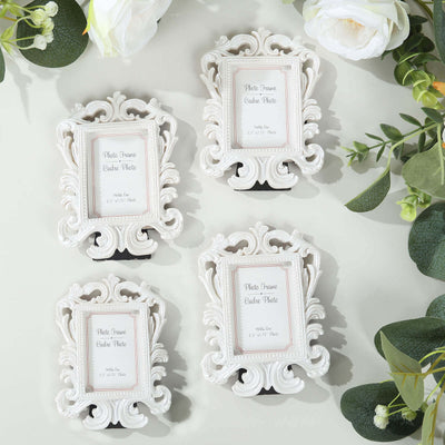 Set of four elegant white photo frames on a light surface.