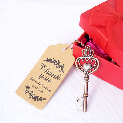 Thank you tag and decorative key next to a red gift box.
