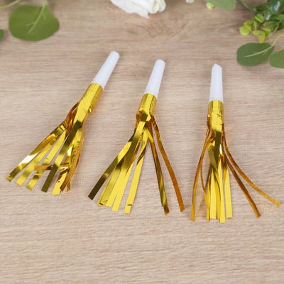 Gold foil party blowers set of three on a wooden surface.