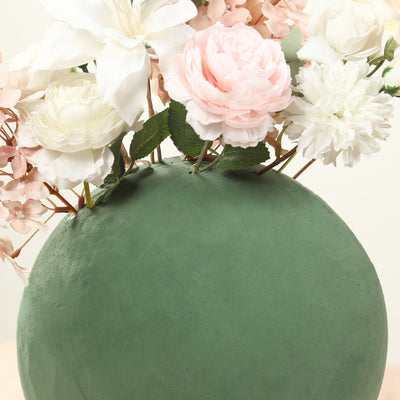 Green spherical vase with assorted artificial flowers