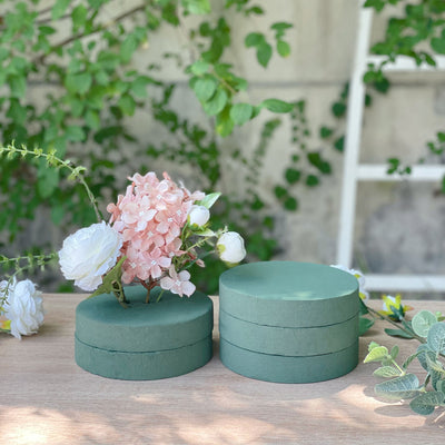 Green foam floral arranging disks with decorative flowers.