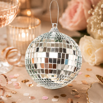 Mirrored disco ball ornament with rose gold party decor and confetti