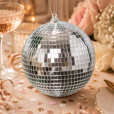 Silver disco ball ornament on a warm, elegant party table setting