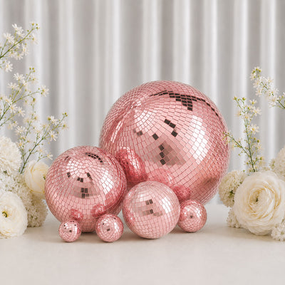 Rose gold disco mirror balls with white flowers on a soft backdrop