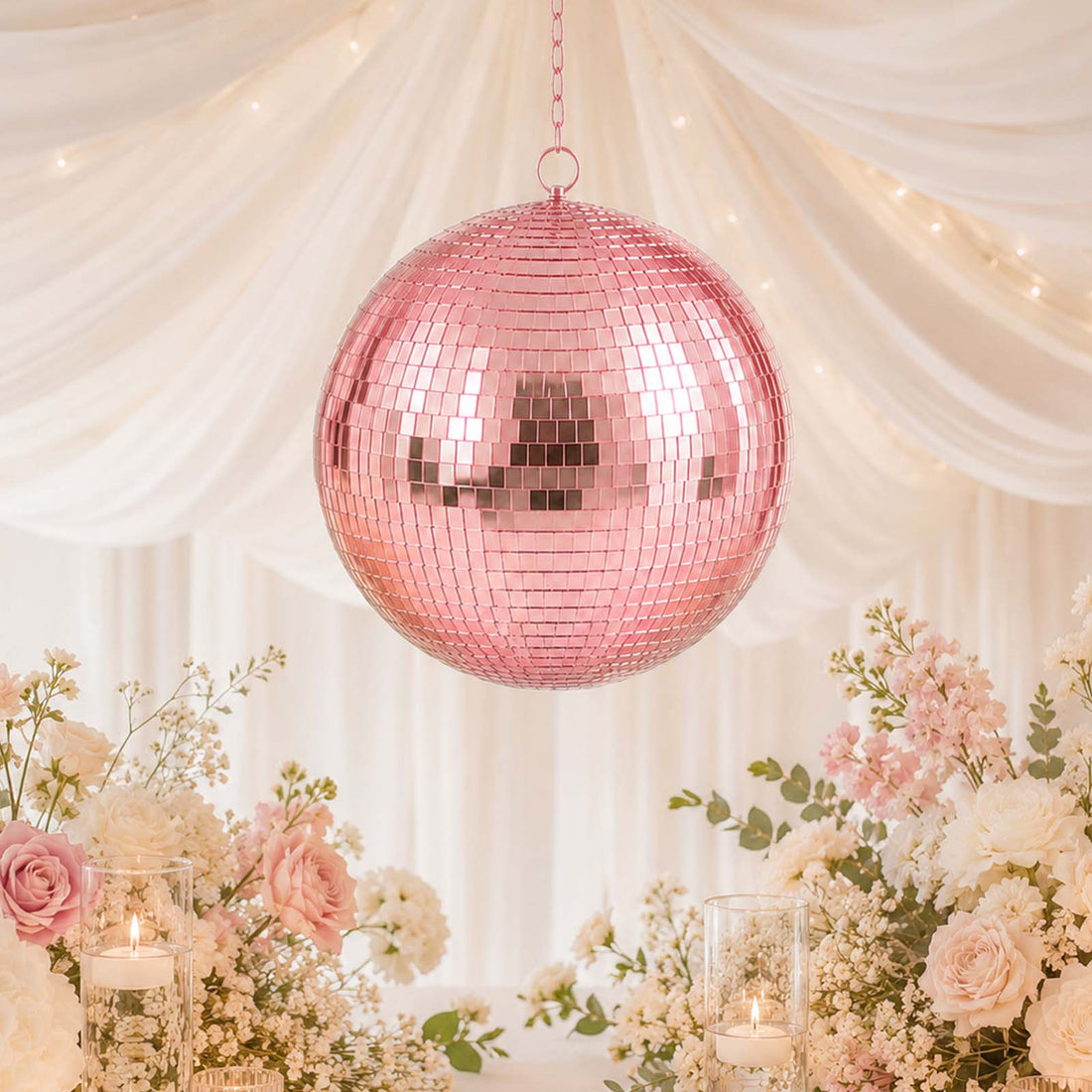 Pink disco ball wedding decor with pastel flowers and candles