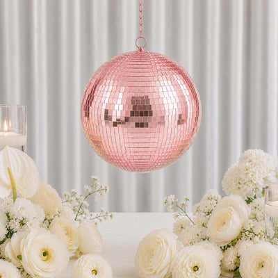 Pink mirrored disco ball hanging above elegant white floral wedding table decor