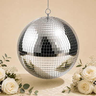 Silver disco ball hanging with white roses on a beige background