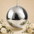 Silver disco ball hanging with white roses on a beige background