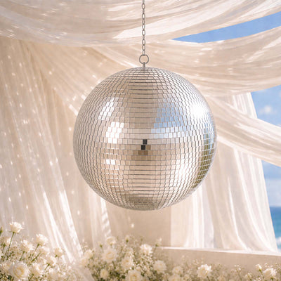 Elegant silver disco ball hanging over a romantic beach wedding backdrop