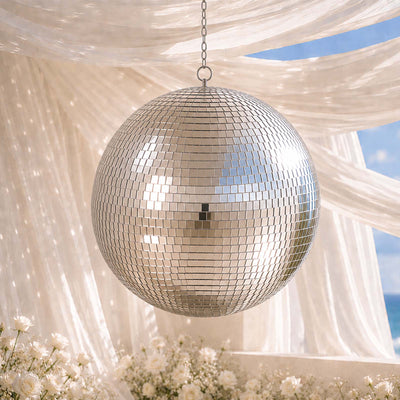 Hanging disco ball under white drapery at an elegant outdoor wedding setting