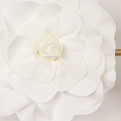 White flower wall decor with layered petals and gold center detail