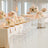 Elegant wedding reception setup with pink rose centerpieces and clear chairs.