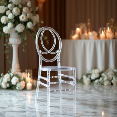 Clear acrylic chair in elegant setting with floral arrangements and candles.
