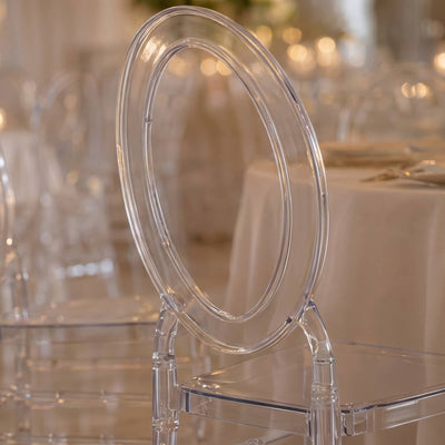 Clear acrylic banquet chair with oval backrest in elegant event setting