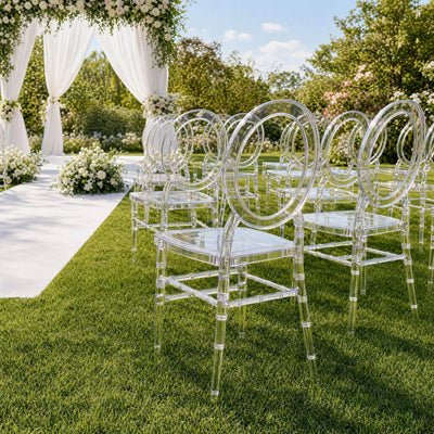 Clear acrylic chairs at elegant outdoor wedding ceremony with floral arch