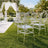 Clear acrylic chairs at elegant outdoor wedding ceremony with floral arch
