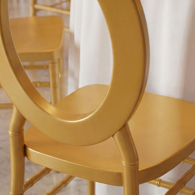 Gold metal chair with oval backrest and round seat in elegant interior