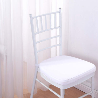 White chiavari chair with padded seat against a light backdrop.