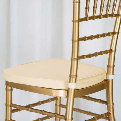 Gold Chiavari chair with cream cushion, studio shot.