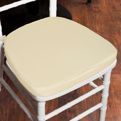 Beige chair cushion on a white chair in a wooden setting.